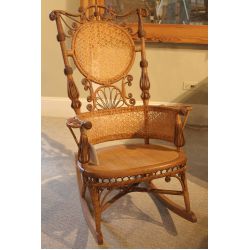Victorian wicker rocker decorated with scrolls with caned back and seat